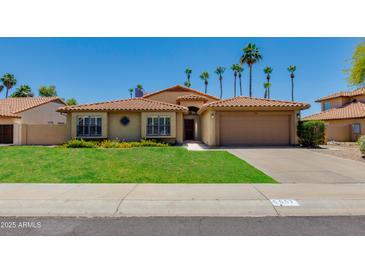 Charming single-story home with a well-maintained lawn and a two-car garage at 5507 E Kings Ave, Scottsdale, AZ 85254