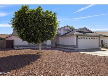 Charming single-story home featuring a well-manicured yard with decorative rock and a mature shade tree at 8620 W Denton Ln, Glendale, AZ 85305