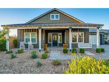 Charming front porch with swing, landscaping, and stone pathway at 11534 N Jerome St, Surprise, AZ 85388