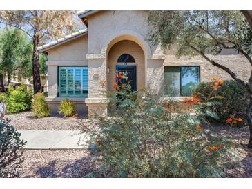 Charming home featuring a stucco facade, arched entryway, and desert landscaping at 14300 W Bell Rd # 312, Surprise, AZ 85374