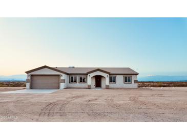 Charming single-story home featuring a neutral color scheme and attached two-car garage at 35672 W Chipman Rd, Tonopah, AZ 85354