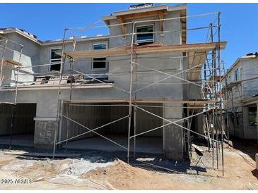 New construction of a two-story home with stucco exterior and scaffolding around the facade at 5831 E Covey Ln, Phoenix, AZ 85054