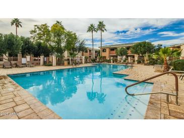 Enjoy the community's refreshing pool surrounded by palm trees and comfortable lounge chairs at 10030 W Indian School Rd # 215, Phoenix, AZ 85037