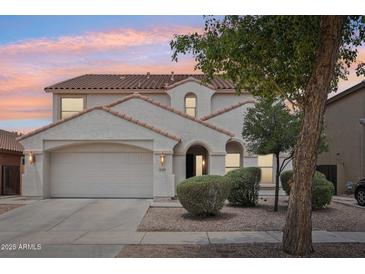 Charming two-story home with a well-maintained front yard, a neutral color scheme, and a terracotta tile roof at 11158 N 162Nd Dr, Surprise, AZ 85379