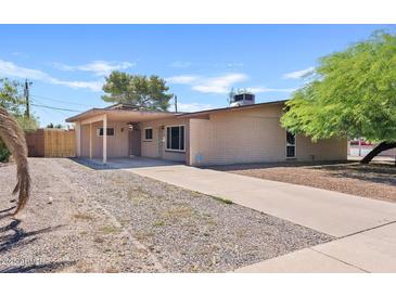 Single story home featuring a brick facade, covered patio, and desert landscaping in front at 12201 N 22Nd Pl, Phoenix, AZ 85022
