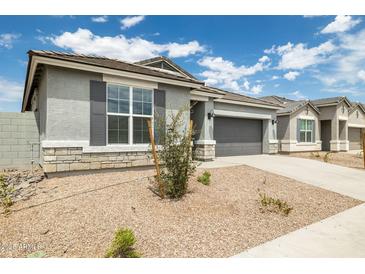 Charming single-story home with gray stucco, stone accents, a two-car garage, and low maintenance landscaping at 17773 W Onyx Ave, Waddell, AZ 85355