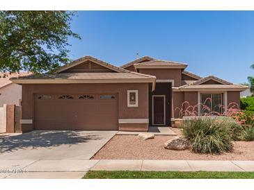 Charming single-story home with a two-car garage and desert landscaping featuring vibrant pink flowering bushes at 3480 E Cullumber Ct, Gilbert, AZ 85234