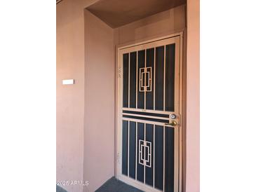 Exterior view of the front door with security screen and decorative design with address number at 4303 E Cactus Rd # 135, Phoenix, AZ 85032