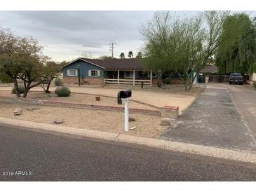 Charming single-story home with mature trees and desert landscaping on an overcast day at 6841 E Vista Dr, Paradise Valley, AZ 85253