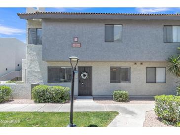 Inviting condo with desert landscaping, green grass, and mature trees at 745 N Dobson Rd # 144, Mesa, AZ 85201