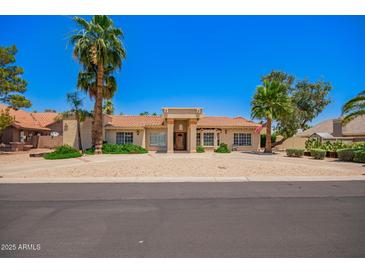 Charming home featuring a tile roof, mature landscaping and desert landscaping for low maintenance at 7722 W Libby St, Glendale, AZ 85308