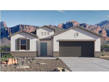 Charming single-story home boasts a stucco exterior, desert landscaping, and stunning mountain views in the background at 9357 S Mineros Dr, Apache Junction, AZ 85120