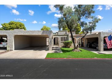 Charming home featuring dual carports, manicured lawn, and decorative stucco exterior at 1120 E Beryl Ave, Phoenix, AZ 85020