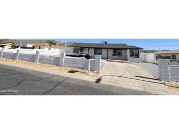 Charming single-story home featuring black trim, a concrete driveway, and a low-walled front yard at 121 E Monte Way, Phoenix, AZ 85042