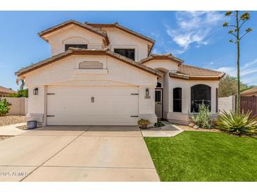 Charming two-story home with a well-manicured lawn, desert landscaping, and a two-car garage at 2934 S Woodruff Cir, Mesa, AZ 85212