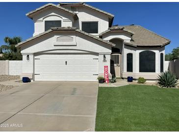 Charming two-story home with a well-maintained lawn and a two-car garage, under a sunny sky at 2934 S Woodruff Cir, Mesa, AZ 85212