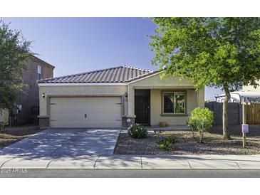 Charming single-story home featuring a well-maintained front yard and a two-car garage at 37390 W Merced St, Maricopa, AZ 85138
