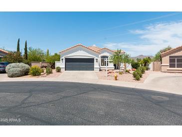Charming home featuring desert landscaping, a gray garage door and a tile roof at 9791 N 118Th Way, Scottsdale, AZ 85259