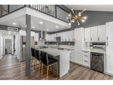 Modern kitchen with white cabinets, gray walls, quartz countertops, island with seating, and stainless steel appliances at 1174 E Belmont Ave, Phoenix, AZ 85020