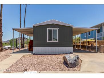 Charming home featuring an extended carport, desert landscaping, and a quaint single window at 12811 N 19Th Pl, Phoenix, AZ 85022