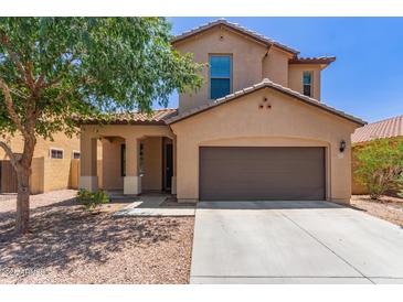 Inviting two-story home with a two car garage and covered porch, landscaped with a mature shade tree at 4051 E Torrey Pines E Ln, Chandler, AZ 85249