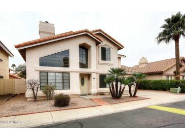 Charming two-story home featuring stucco siding, tile roof, desert landscaping, and a welcoming entrance at 4437 E Villa Theresa Dr, Phoenix, AZ 85032