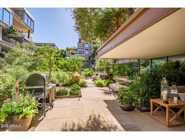 Expansive patio showcases lush landscaping, grill area, comfortable seating for outdoor relaxation and entertaining at 7167 E Rancho Vista Dr # 3002, Scottsdale, AZ 85251