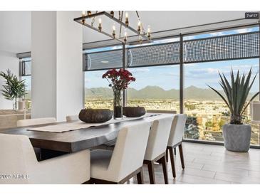 Bright dining room features a modern chandelier, large windows, and panoramic city and mountain views at 7180 E Kierland Blvd # 916, Scottsdale, AZ 85254
