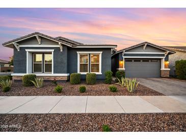 Charming home with a well-maintained front yard featuring desert landscaping and a two-car garage at 10322 E Topaz Ave, Mesa, AZ 85212