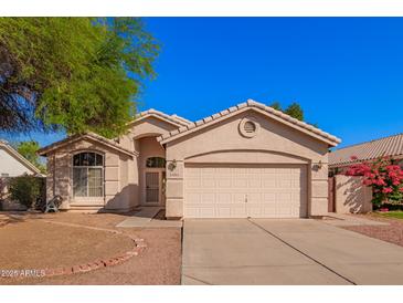 Charming single-story home with a two-car garage and a well-maintained front yard at 10923 W Ivory Ln, Avondale, AZ 85392