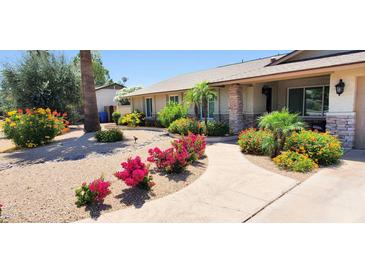 Charming home featuring a stone facade, walkway, and colorful desert landscaping in the front yard at 4617 E Emile Zola Ave, Phoenix, AZ 85032