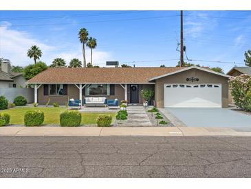 Charming single-story home with a well-manicured front yard and inviting outdoor seating area at 5332 N 81St Pl, Scottsdale, AZ 85250