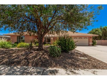 Charming single-story home featuring a well-manicured yard with mature shade tree at 837 W Keating Ave, Mesa, AZ 85210