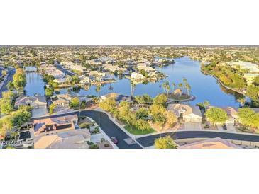 Aerial view of a neighborhood with lake, palm trees, and single Gathering homes at 8759 W Port Au Prince Ln, Peoria, AZ 85381