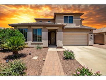 Charming two-story home with a well-manicured front yard and an attached two-car garage at 11936 W Alvarado Rd, Avondale, AZ 85392