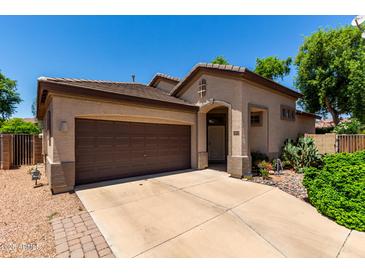 Charming single-Gathering home with a well-maintained front yard and a two-car garage on a sunny day at 14314 W Lexington Ave, Goodyear, AZ 85395