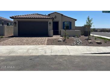 Charming single-story home features a tile roof, neutral stucco, blue shutters, and a 2-car garage at 18153 W Hiddenview Dr, Goodyear, AZ 85338