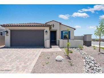 Charming single-story home with a well-maintained front yard, desert landscaping, and a two-car garage at 18153 W Hiddenview Dr, Goodyear, AZ 85338