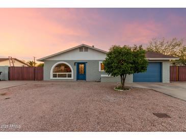 Charming single-story home with blue accents and a unique arched window, set against a desert landscape at 332 S 83Rd Pl, Mesa, AZ 85208