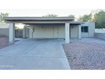 Exterior home elevation featuring a carport, xeriscaping, and neutral color palette at 4902 S Fair Ln, Tempe, AZ 85282