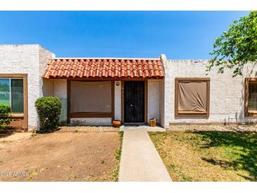 Charming home exterior with decorative tile roof, cozy front patio and easy access to the front door at 6606 N 46Th Ave, Glendale, AZ 85301