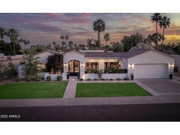 Inviting single-Gathering home showcasing manicured lawn, desert landscaping and large arched main entry at 8045 E Del Caverna Dr, Scottsdale, AZ 85258