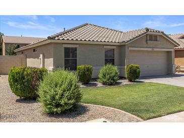 Charming single-story home featuring a neutral color palette, well-manicured lawn, and tidy landscaping at 9329 E Olla Ave, Mesa, AZ 85212
