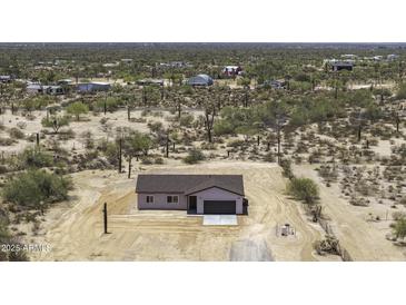 An aerial view shows this single-Gathering home surrounded by desert vegetation and other structures at 10772 N Biznaga St, Florence, AZ 85132