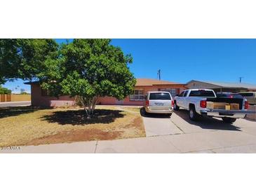 Charming single-story home with a well-maintained lawn and mature tree, exuding curb appeal at 1438 W 7Th St, Tempe, AZ 85281