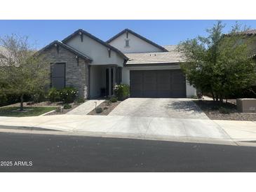 Charming single-story home featuring stone accents, a neutral color palette, and a well-manicured front yard at 26943 N 74Th Ave, Peoria, AZ 85383