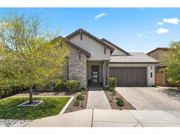 Beautiful single-story home featuring stone accents, a spacious driveway, manicured lawn, and a two-car garage at 26943 N 74Th Ave, Peoria, AZ 85383