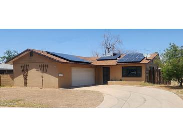 Charming single-story home with solar panels and a two-car garage at 3208 W Port Royale Ln, Phoenix, AZ 85053
