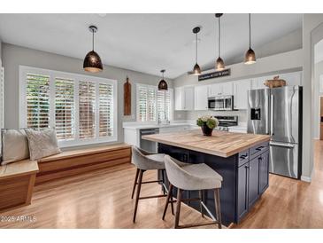 Bright kitchen with modern appliances, a center island with butcher block, and an inviting window seat at 4350 E Gatewood Dr, Phoenix, AZ 85050