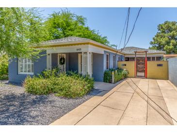 Charming single-story home with blue painted brick, mature landscaping, and a welcoming front porch at 445 W 1St St, Mesa, AZ 85202